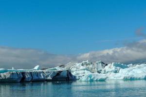 leuchtend blauer Eisberg, der im blauen kalten Wasser des Jokulsarlon-Sees in Island schwimmt 46 foto