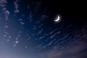 Sehen Sie den islamischen Mond am Nachthimmel. Abendhimmel und die Weite im Dunkeln sind wunderschöne funkelnde Sterne. das mondsichelkonzept, das symbol des islams, beginnt den monat ramadan, eid al fitr foto