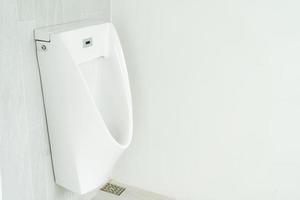 weißes Urinal in der Toilette. weißes keramisches Urinal-Nachttopf-Innendesign mit schöner Marmorwand Männer öffentliche Toilette oder Toilette foto