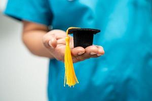 asiatische arztstudie lernen mit abschlusslückenhut in der krankenstation, kluges, geniales bildungsmedizinkonzept. foto