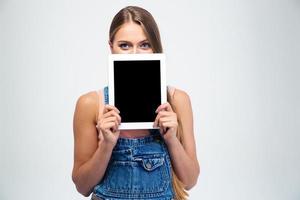 Frau, die ihr Gesicht mit Tablet-Computer bedeckt