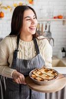 Porträt einer Frau, die Kürbiskuchen für Thanksgiving-Dinner in der heimischen Küche zubereitet foto