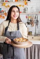 Porträt einer Frau, die Kürbiskuchen für Thanksgiving-Dinner in der heimischen Küche zubereitet foto