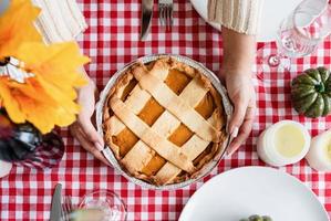 Blick von oben auf die Frau, die Kürbiskuchen für das Thanksgiving-Dinner in der heimischen Küche zubereitet foto