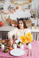 Frau bereitet Thanksgiving-Dinner in der heimischen Küche zu und dekoriert foto