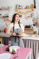 Porträt einer Frau, die Kürbiskuchen für Thanksgiving-Dinner in der heimischen Küche zubereitet foto