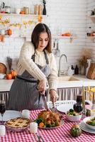 Frau bereitet Thanksgiving-Dinner in der heimischen Küche zu und dekoriert foto