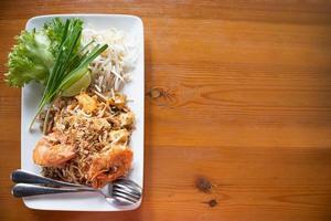 Pad Thai, gebratene Reisnudeln mit Süßwassergarnelen, serviert mit Gemüse, Sprossen und Zitrone foto