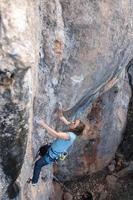 Eine Frau klettert auf einen Felsen foto