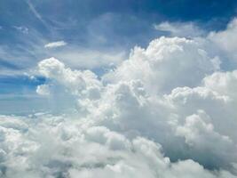 Blick aus dem Fenster des Flugzeugs. der Himmel mit weißen Wolken und blauem Hintergrund. klares Wetter mit leicht sinkendem Sonnenlicht foto