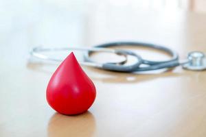 stethoskop und ein rotes blut auf holz gelegt foto