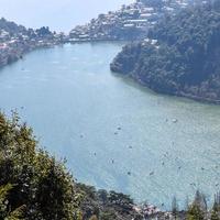 volle ansicht des naini-sees während der abendzeit nahe der einkaufsstraße in nainital, uttarakhand, indien, schöne ansicht des nainital-sees mit bergen und blauem himmel foto