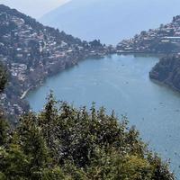 volle ansicht des naini-sees während der abendzeit nahe der einkaufsstraße in nainital, uttarakhand, indien, schöne ansicht des nainital-sees mit bergen und blauem himmel foto