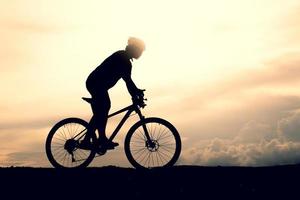 Silhouetten von Mountainbikes und Radfahrern am Abend fröhlich. reise- und fitnesskonzept foto