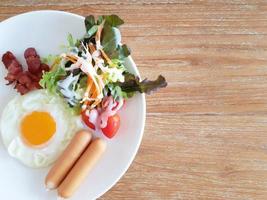 eine Nahaufnahme von Eiern, Speck, Schinken und Wurst auf Toast foto