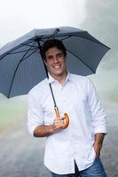junger Mann, der Regenschirm hält