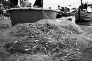 Seenetze - Angelausrüstung oder Tackle als Texturhintergrund mit natürlichem Sonnenlicht und Schatten. schwarz-weißer strukturierter Hintergrund von Fischernetzen, Meeresdesign für das Handwerk der Fischer.