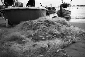 Seenetze - Angelausrüstung oder Tackle als Texturhintergrund mit natürlichem Sonnenlicht und Schatten. schwarz-weißer strukturierter Hintergrund von Fischernetzen, Meeresdesign für das Handwerk der Fischer.