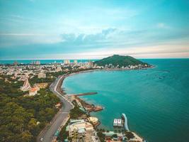 Luftaufnahme der Stadt Vung Tau mit wunderschönem Sonnenuntergang und so vielen Booten. Panoramablick auf die Küste von Vung Tau von oben, mit Wellen, Küste, Straßen, Kokospalmen und dem Berg Tao Phung in Vietnam. foto