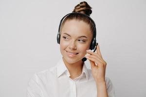 freundliche frau im headset, die mit dem kunden spricht foto