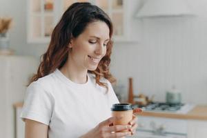 junge attraktive hausfrau mit tasse kaffee in der küche am morgen. skandinavisches stilvolles interieur. foto