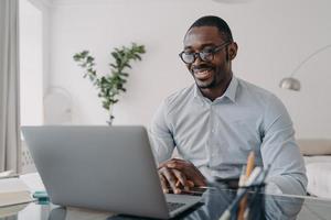 Online freiberuflicher Remote-Job. Afroamerikaner spricht vor der Kamera des PCs. foto