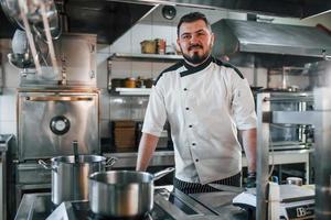 mit professionellem Werkzeug. professioneller koch, der essen in der küche zubereitet foto