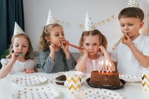 Süßer Kuchen steht auf dem Tisch. Geburtstag feiern. Gruppe von Kindern ist tagsüber zusammen zu Hause foto