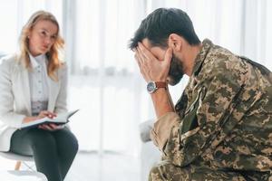 Seitenansicht. soldat hat drinnen eine therapiesitzung mit einem psychologen foto