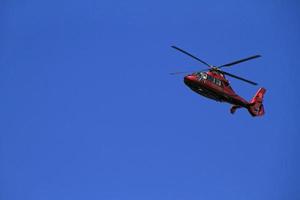Roter Hubschrauber im blauen Himmel foto