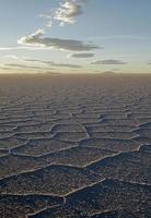 Wunderschöne Muster auf der Oberfläche der Salinen von Salar de Uyuni, Bolivien, während des Sonnenuntergangs foto