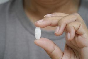 Nahaufnahme einer Frau mit Pille, die Medizin zeigt. foto