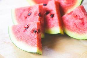 Wassermelonenscheibe auf Holzhintergrund - Nahaufnahme von frischen tropischen Früchten der Wassermelone foto