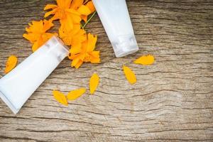 lotionsflasche kräuter mit gelber blume auf holzhintergrund - natürliche lotion für gesichts- und körperschönheitsmittel und spa-bio-minimalistischen lebensstil foto