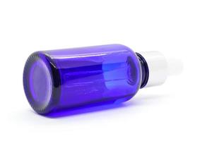 Blaue Glastropfenserumflasche auf weißem Hintergrund foto