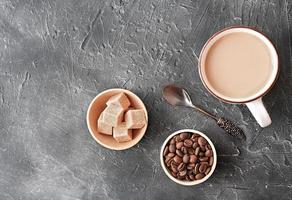 Flacher weißer Kaffee in einer Tasse. brauner Zucker und Kaffeebohnen foto