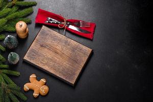 Ein leeres Holzschneidebrett mit Holzbesteck auf einem weihnachtlichen Küchentisch foto