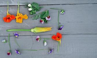 essbare Blumen auf einem grauen Tisch. Essen Knolling. foto