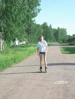 Teenager Mädchen Rollschuhlaufen im Sommerpark. schlankes sportliches Mädchen in Freizeitkleidung. aktive Freizeitgestaltung für Zehner foto