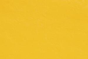 lebendiger gelber Stuckwandhintergrund. gelb gestrichene Zementwand Hintergrundtextur. foto