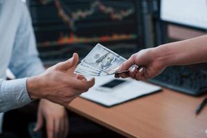 Bezahlung für die Arbeit. Tag des Gehalts im modernen Büro mit Bildschirmen mit Grafiken darauf foto