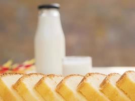 Butterkuchen und Flasche mit Glas Milch auf weißem Holztisch foto