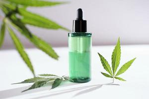 CBD-Gesichtsöl aus Cannabisextrakt für eine natürliche Hautbehandlung. naturkräuterkosmetik, hautbehandlungskonzept. Marihuana-Blätter. foto