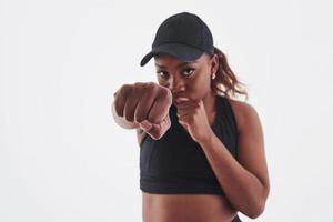 einen Schlag werfen. junge schöne Afro-Amerikanerin im Studio vor weißem Hintergrund foto