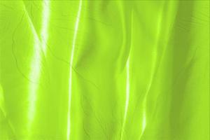 grüne satin stoff textur weich verwischen mit palmblättern muster hintergrund foto