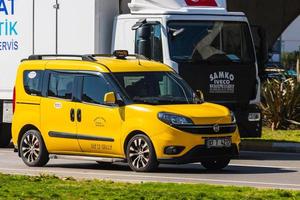 antalya türkei 04. märz 2022 gelbes taxi fiat doblo fährt an einem warmen sommertag vor dem hintergrund einer brücke schnell auf der straße foto