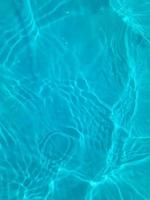 defocus verschwommene, transparente, blaue, klare, ruhige wasseroberflächenstruktur mit spritzern und blasen. trendiger abstrakter naturhintergrund. Wasserwellen im Sonnenlicht. Hintergrund des blauen Wassers. foto