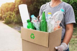 frauenhand, die kastenmüll zum recyceln hält foto