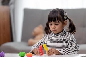 asiatische kinder spielen mit tonformen und lernen spielerisch foto