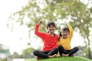 Kind spielt auf Spielplatz im Freien. kinder spielen auf dem hof der schule oder des kindergartens. aktives kind auf bunter rutsche und schaukel. gesunde sommeraktivität für kinder. kleines Mädchen, das draußen klettert. foto